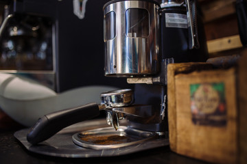 barista grinding fresh coffee into bayonet. coffee grinder in the coffee shop