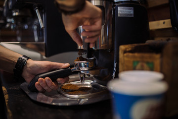 Fototapeta na wymiar coffee grinder in the coffee shop. Barista grinding fresh coffee into bayonet
