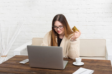 Young woman in glasses online shopping at home