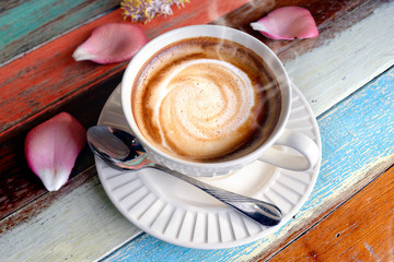 Hot cappuccino coffee on the wooden table.