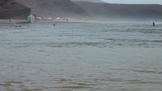 A lone fisherman returns from fishing on the Atlantic Ocean in Morocco. Goes on water with a fishing rod in a fog