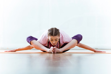 Beautiful young woman practicing yoga at home.