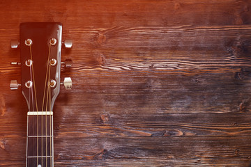 Black acoustic guitar on wooden background