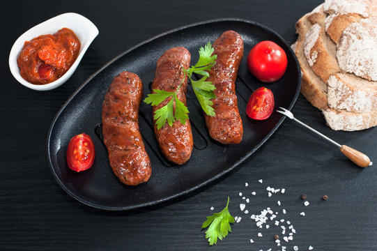 Fried sausages with herbs in a pan