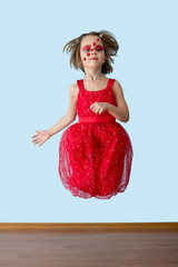 Naklejka premium Little girl with ladybug face paint jumping