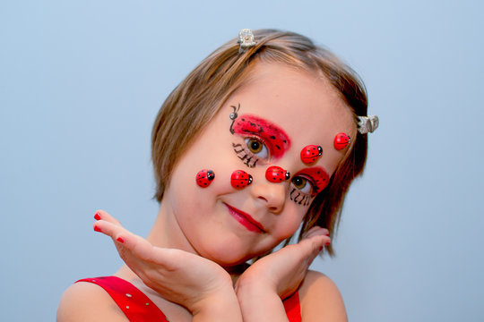 Little girl with ladybug face paint - Powered by Adobe