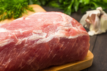Juicy raw meat with spices, pepper, sea salt and herbs lies on a dark wooden background