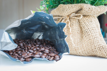 Coffee beans in bag of aluminum foil with sack.
