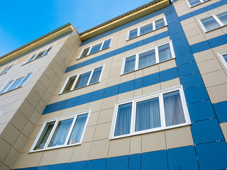 Finishing of the facade of the new apartment house with ceramic tiles