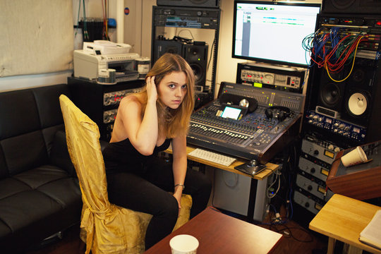 Portrait of young woman sitting in recording studio