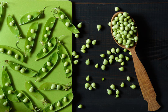 Healthy fresh green peas and pods in woooden spoon.  Stylish food background. Horizontal view