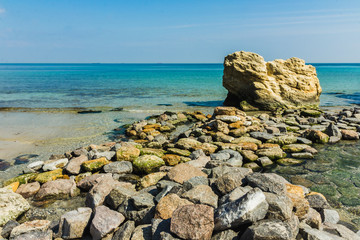 Beautiful seascape. Sea and rock at the sandy beach. Nature composition.