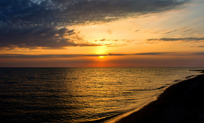 Cloudy summer sunset at sea beach