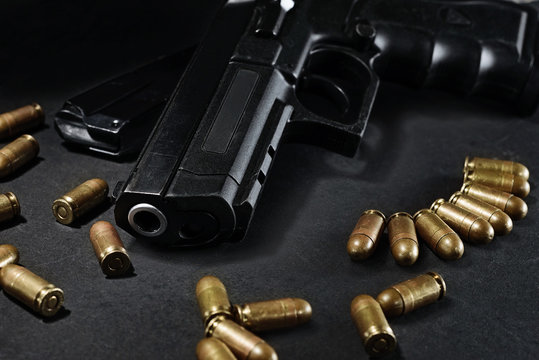 handgun with ammunition on a black surface
