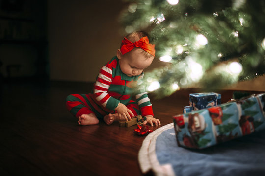 Girl playing with toy while sitting by Christmas tree at home