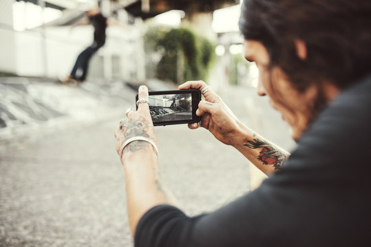 Man taking picture through smartphone outdoors
