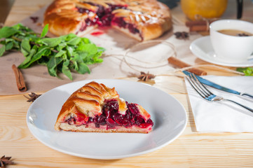 Piece of sweet pie, tart, cake with jellied fresh cherry on the white plate on the wooden served table. Close up, Selective Focus