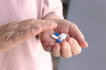 Hands of senior woman with pills, closeup