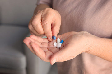 Hands of senior woman with pills, closeup