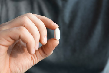 Male hand with pill, closeup