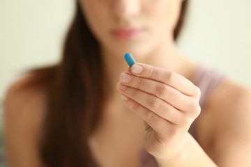 Young woman with pill, closeup