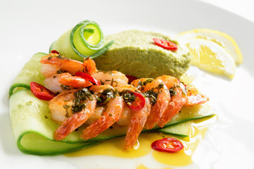 fried prawns on cucumber with avocado puree, chili and lemon