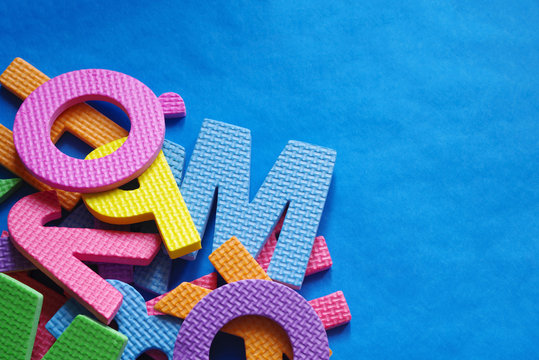 Colorful letters of the alphabet on a blue background, copy space 