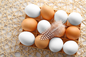 Easter eggs in wooden carrier on light background