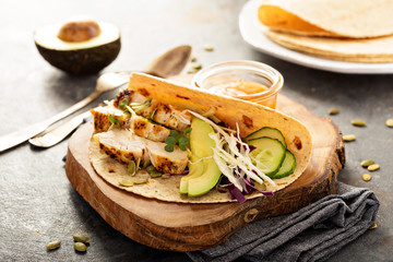 Making tacos with grilled chicken and avocado