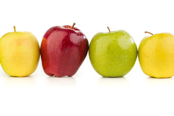 Multicolored apples in a row on a white table