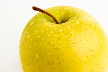 Bright ripe yellow apple in water drops