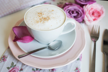 Cup of cappuccino and roses