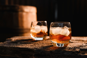 Glass of whiskey on wooden background close up