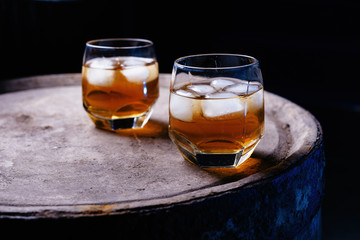 Glass of whiskey on wooden background close up