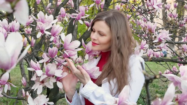 beautiful girl among magnolia pink blossom sping tree flowers