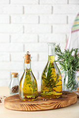 Obraz na płótnie Canvas Olive oil with spices on table in light room