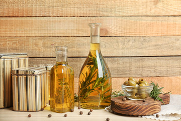 Olive oil with spices on wooden background