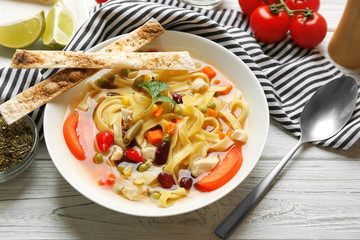 Chicken tortilla soup in plate on wooden table