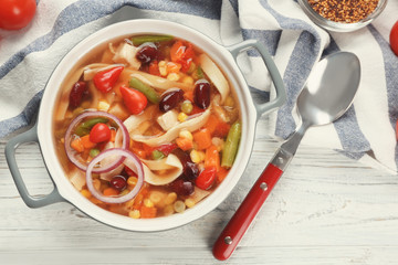 Chicken tortilla soup in pot on wooden table