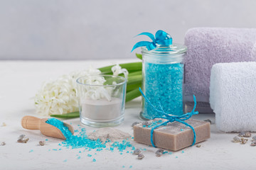 Obraz na płótnie Canvas Cosmetic clay powder, homemade clay soap and blue sea salt on white background.