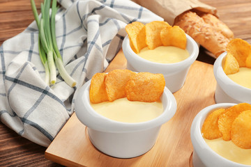Beer cheese dip with chips in bowls on wooden board