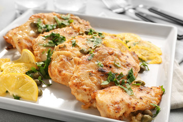 Tasty Italian chicken piccata with lemon on plate