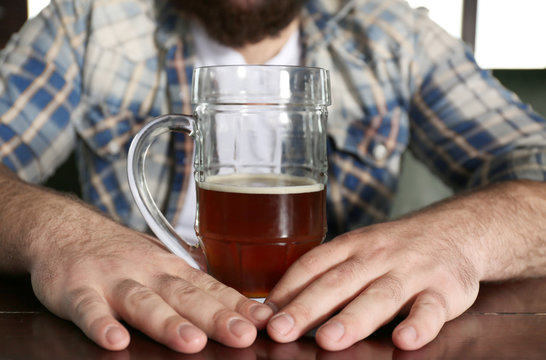 Man with glass of beer in pub, closeup