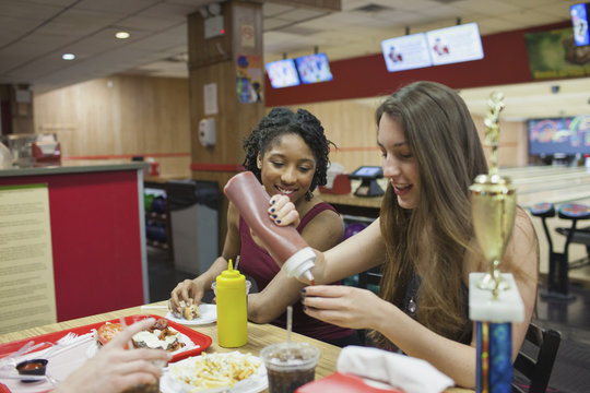 Young women eating at a diner together.