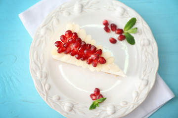 Tasty cheesecake slice with pomegranate on plate