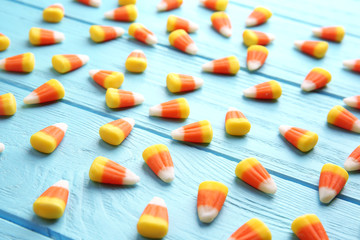 Colorful Halloween candy corns on wooden background