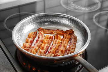 Pan with strips of fried bacon on stove