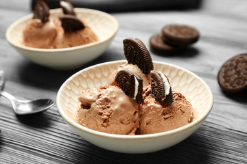 Tasty ice-cream with cookies in bowl on wooden background