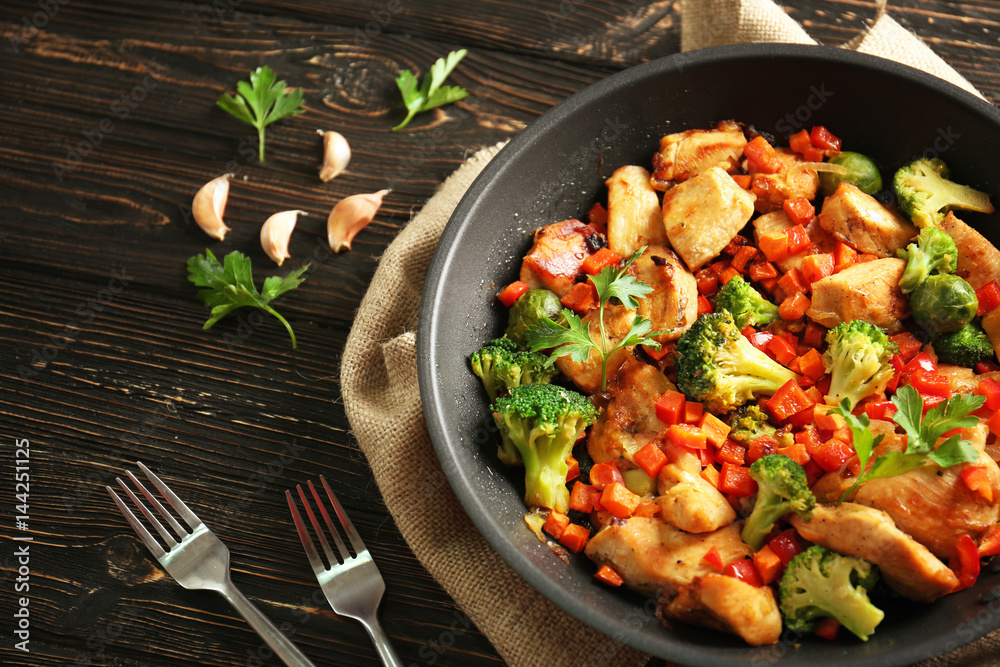 Wall mural chicken stir fry with cutlery and spices on table