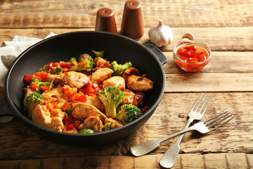 Chicken stir fry with cutlery and spices on table